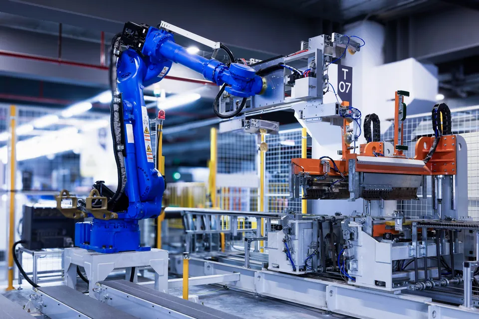 Ramię robota przemysłowego przy stanowisku z przyrządem w hali produkcyjnej